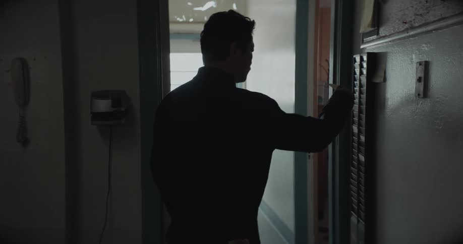 Man punches his time card before heading toward the door