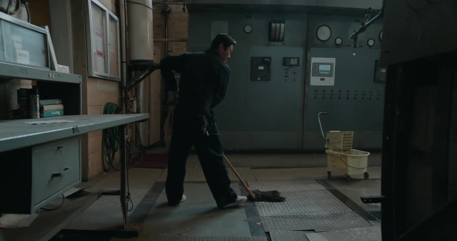 Fisheye view shows man mopping floor in manufacturing plant