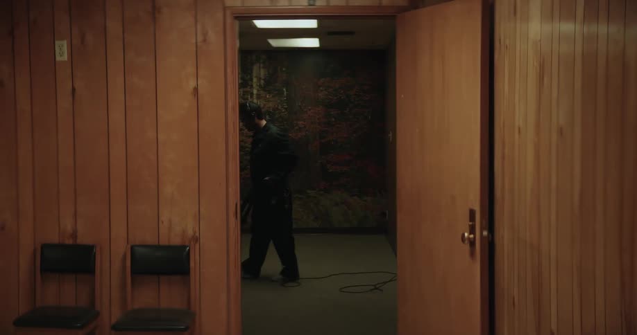 A man is vacuuming a room in a building