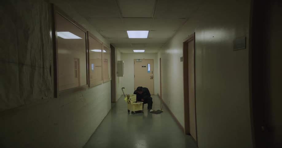 A male employee is cleaning a hallway