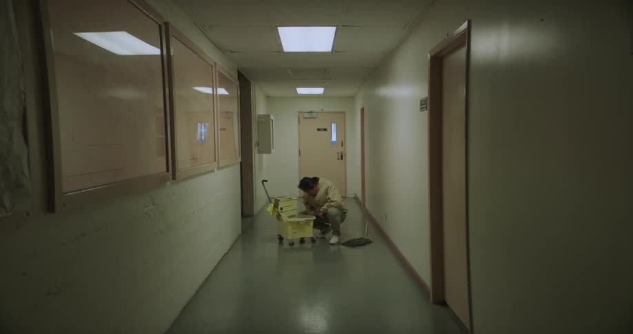 A person is mopping the hallway in a building