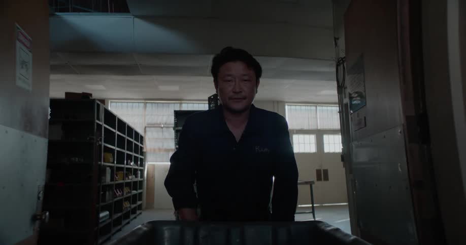 Man pushes a cart through hallways in a building interior