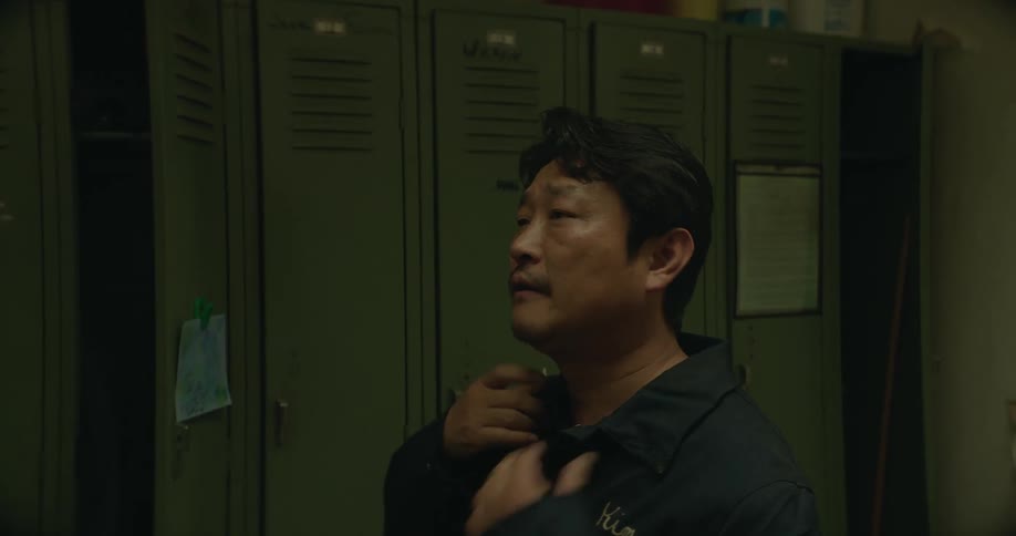 A man is getting dressed in a locker room