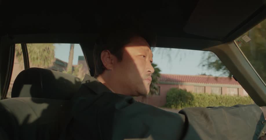 A man is driving his car during the daytime