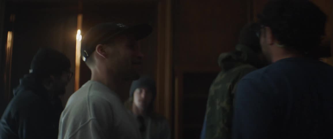 Man hugs another man in a dim room