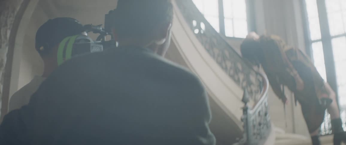 A camera man is followed by an assistant