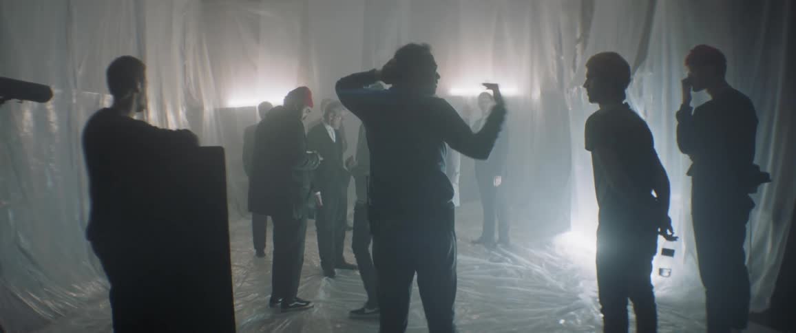 A group of people stand together talking and pointing