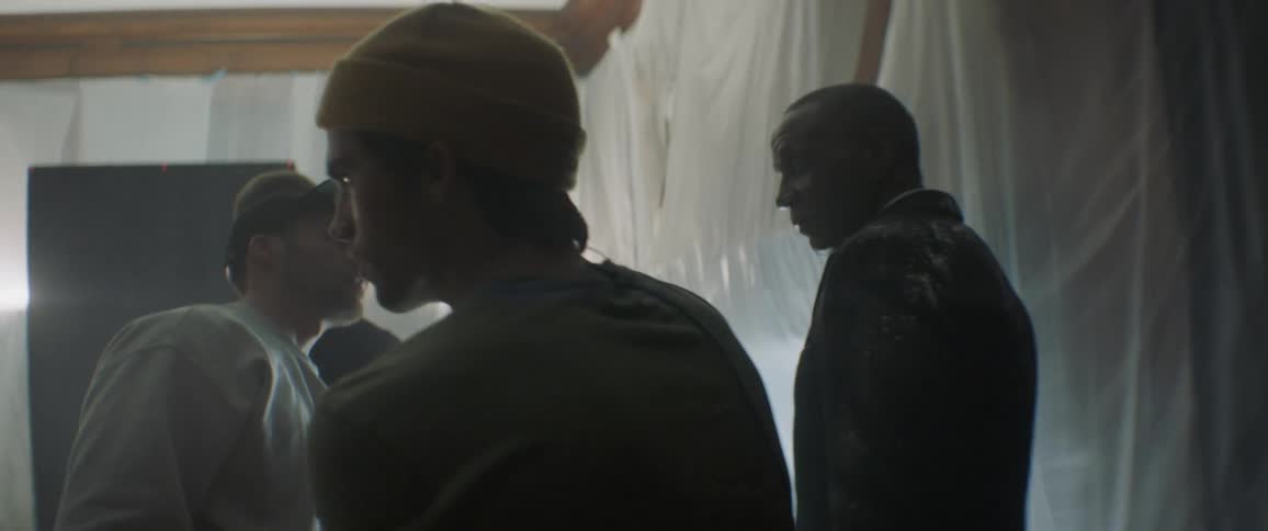 A man pours some salt on a man's suit jacket