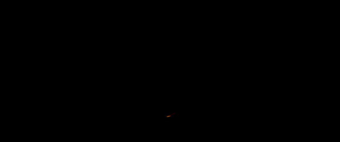 A person shines a light briefly in the dark