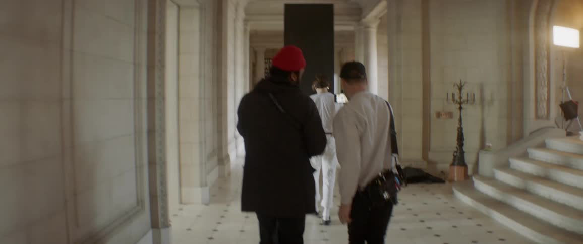 Film crew walks down a hallway