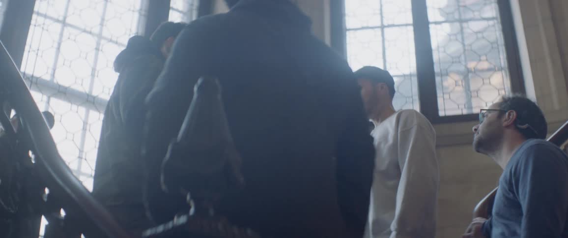 A group of people talk on the staircase
