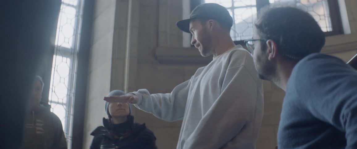 A man gestures as he explains what he's looking for to a camera crew