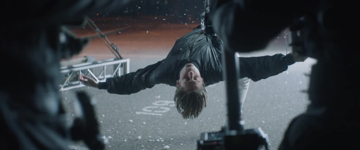 A person is hanging backwards with a wire holding him up