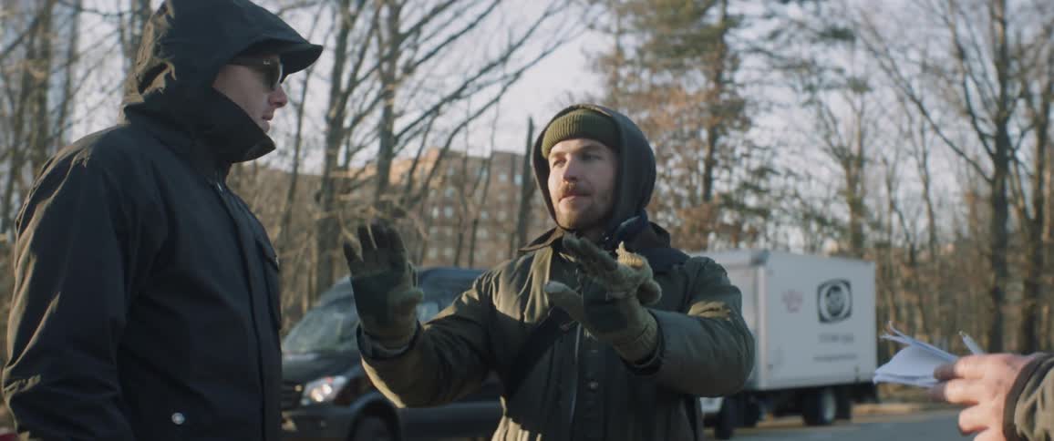 Two men talk together in the parking lot