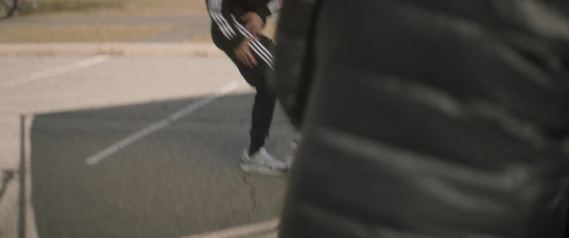 Man dances outside on a sport court