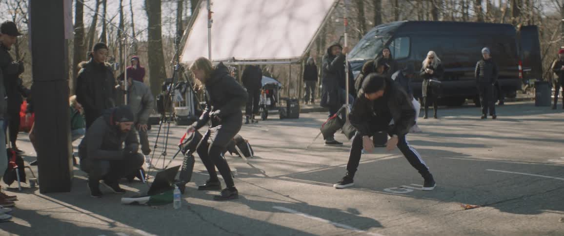 A woman directs and choreographs dance moves on an outdoor set