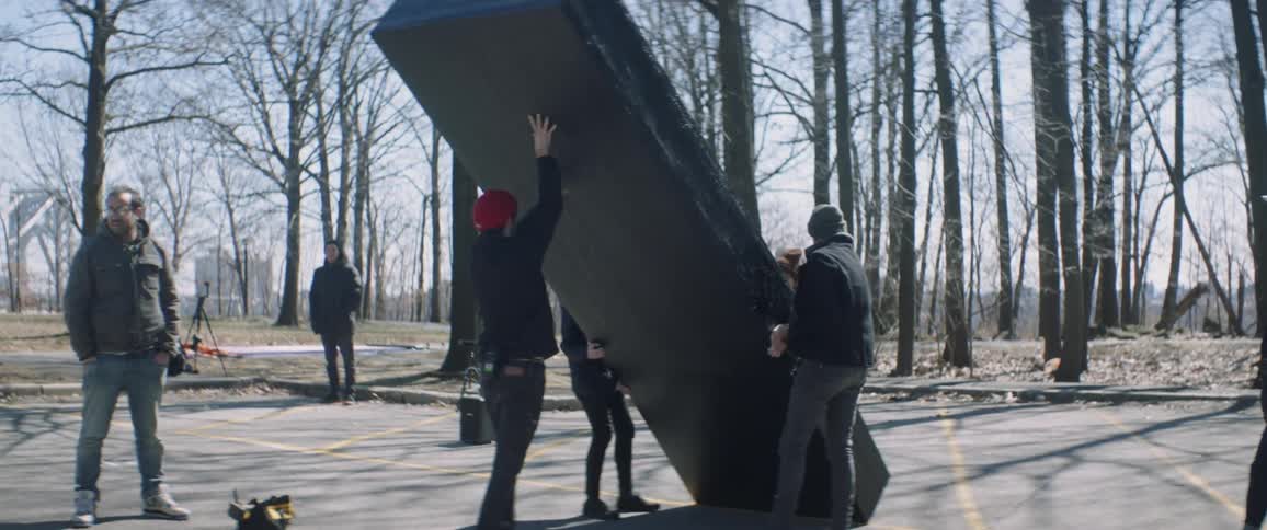 A crew set up a large box on a film site