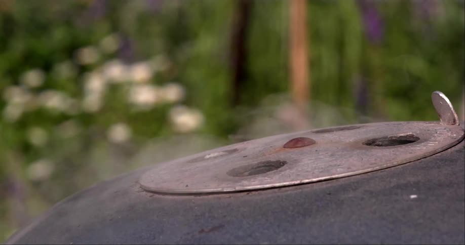 Steam is rising from the holes on a grill