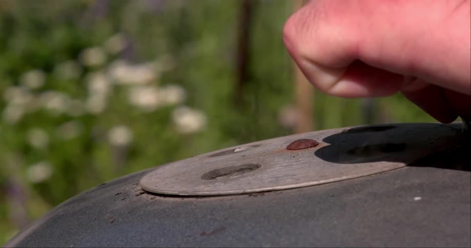 Steam rises from the holes on a barbecue