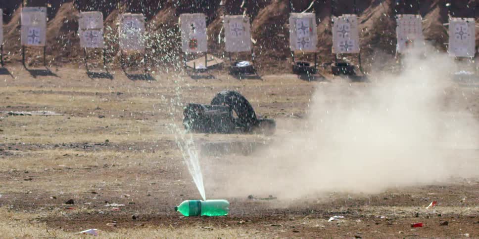 A bottle filled with water explodes in the middle of a field