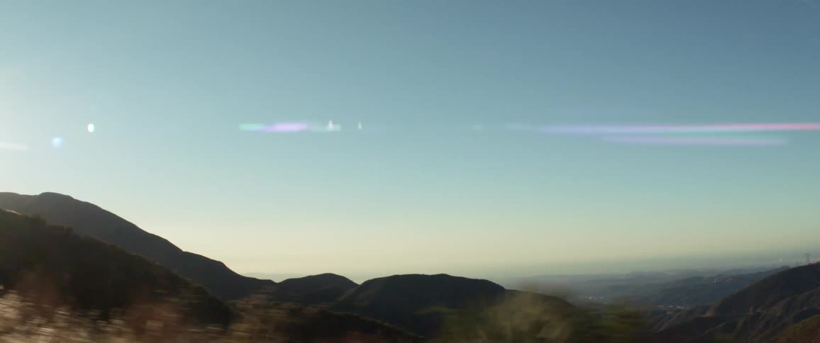 Moving shot taken from a vehicle of hill or mountainous landscape