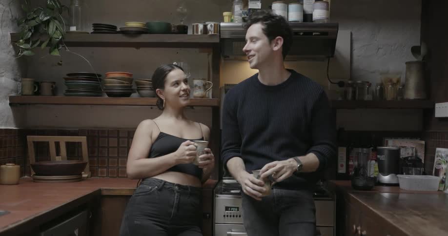 A man and a woman talking enthusiastically in the kitchen