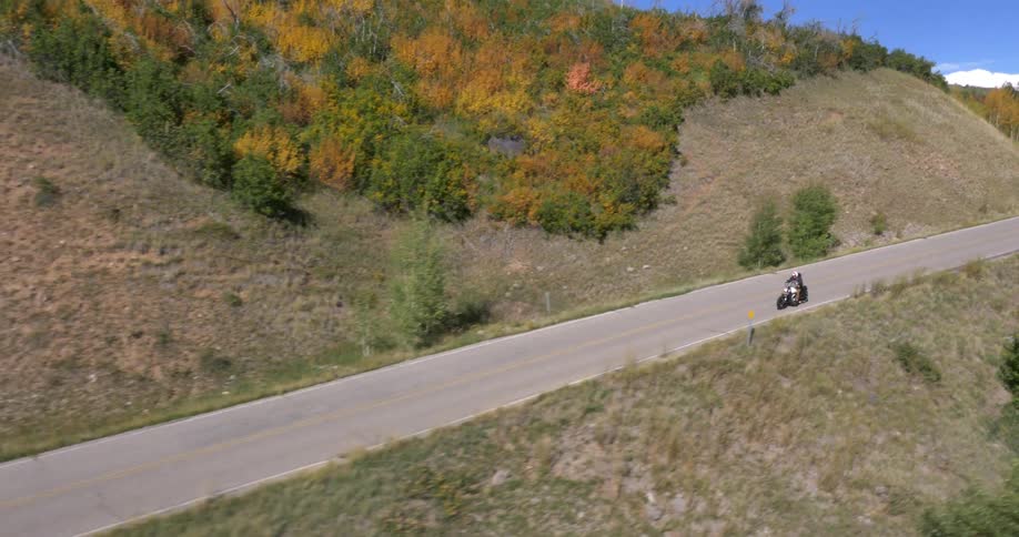 Person riding standing up on a motorcycle down a highway