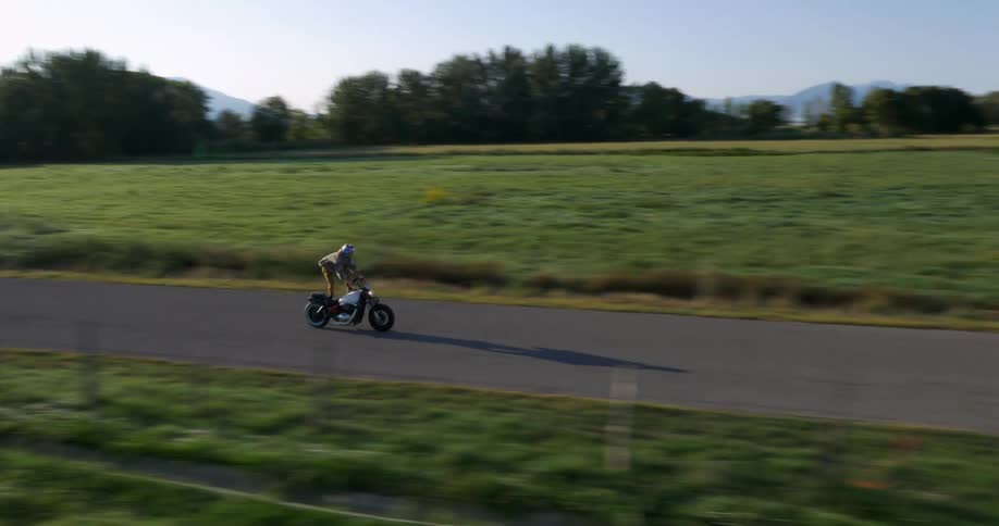 Man balances on a motorcycle in a rural area
