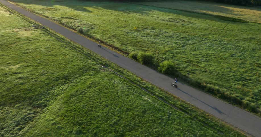 Two people ride their motorcycles below