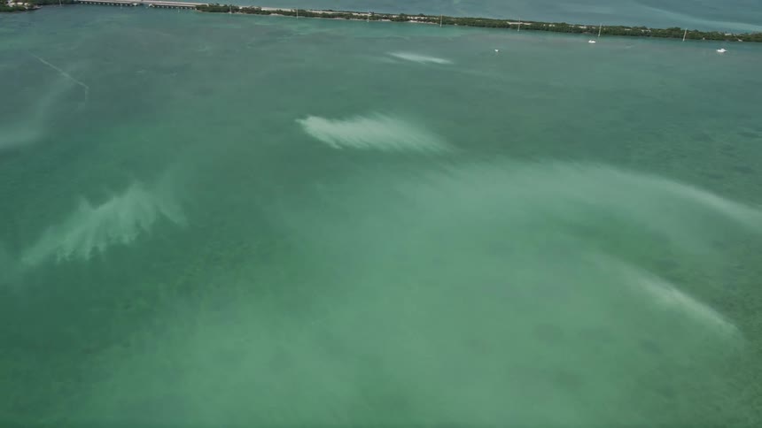 Filmed from an aerial perspective this clip showcases the murky water of the Atlantic Ocean off the shore of Little Torch Key with a stunning view of the surrounding coastline sunny weather and tilting down shots of the water body