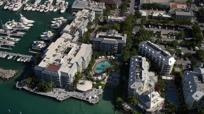 An aerial view of Pier House Resort and Caribbean Spa in Key West FL showcasing the hotels pools shoreline sunbathers and vacationers enjoying leisure activities during the summer months