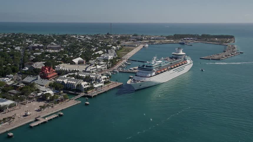 A beautiful Royal Caribbean Cruise ship is seen docked along the sunny shores of Key West Florida during summertime