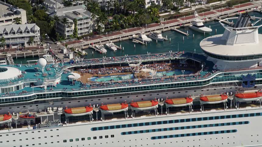 Aerial footage of sunbathers lounging around a swimming pool on a Royal Caribbean cruise ship in Key West Florida during summertime
