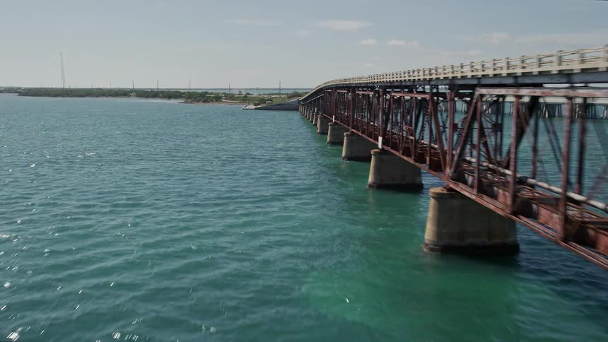 Aerial footage of flying over Old Bahai Honda Bridge leading to a small island in Florida during daytime