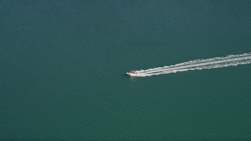 Aerial view of a speedy boat tracking through the waves of Key West Florida on a sunny summer day