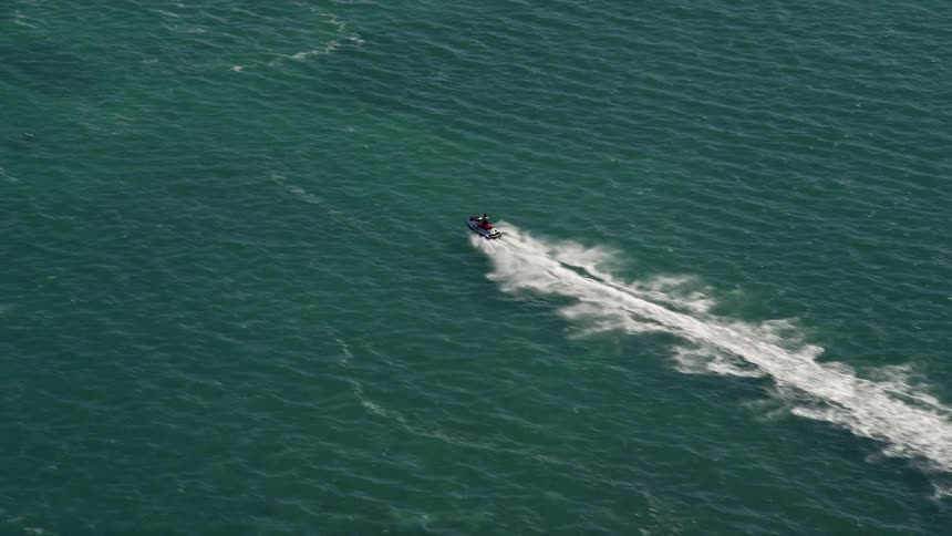 A jet skier races across the ocean in Key West Florida captured in stunning daytime aerial footage during summer