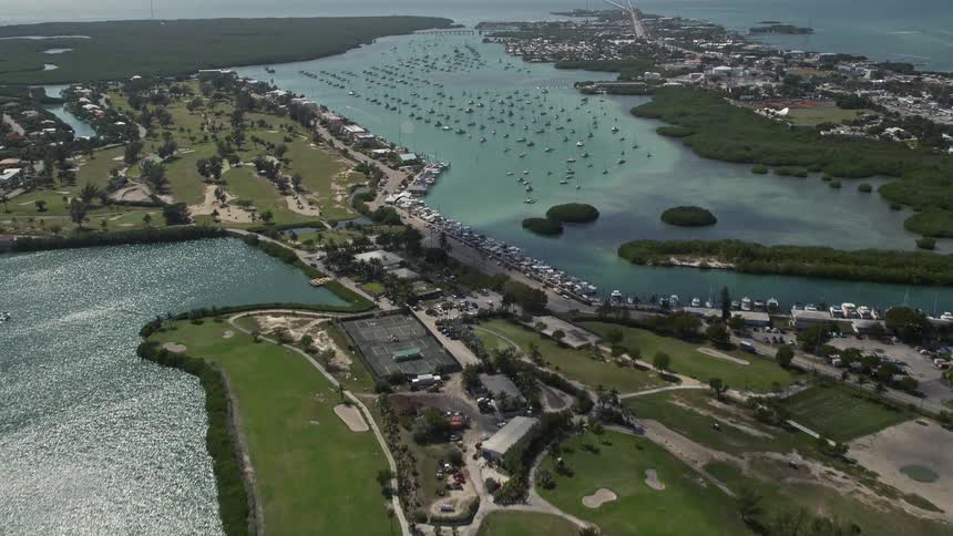 Aerial flyover of Sombrero Country Club approaching Boot Key Harbor in Marathon Florida - showcasing the harbor sailboats golf course and shoreline
