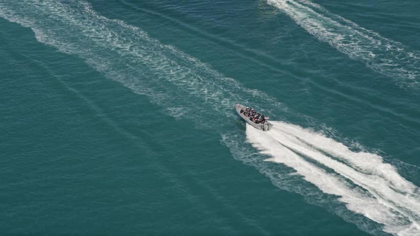 A tracking speedboat races across the water by Key West Florida during summer