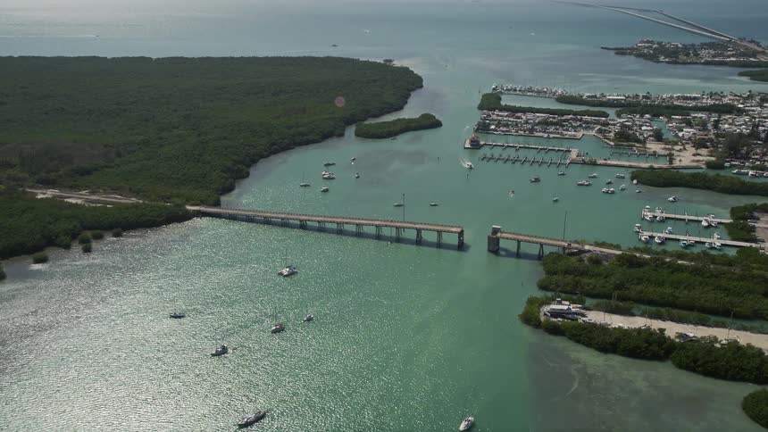 Aerial footage of sailboats and fishing boats navigating through Boot Key Harbor in Marathon Florida
