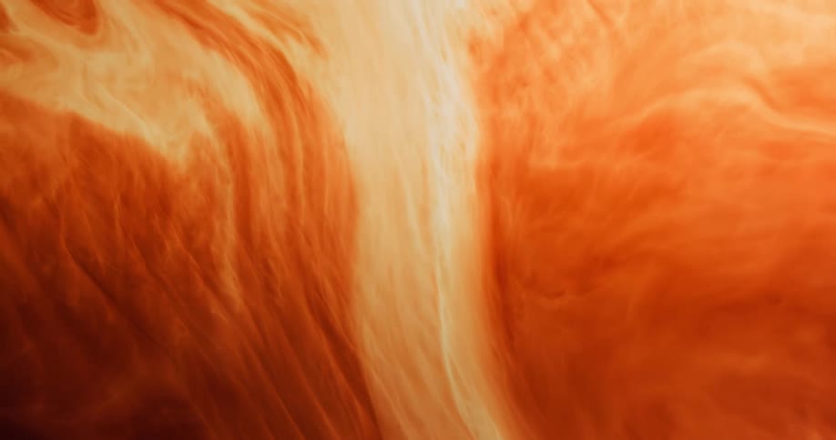 A swirling liquid in shades of light brown and orange moves like a wave