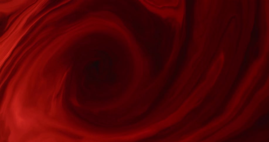 Red liquid combines with black liquid to create a swirl pattern