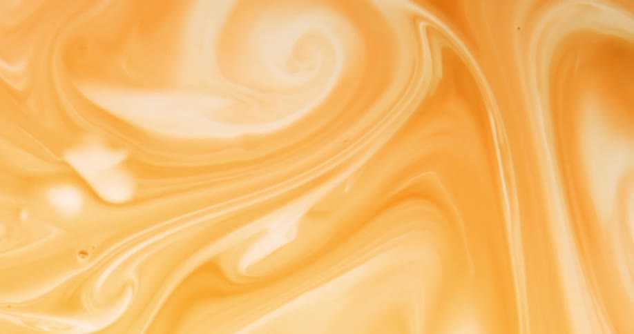 Close up of yellow liquid flowing and swirling
