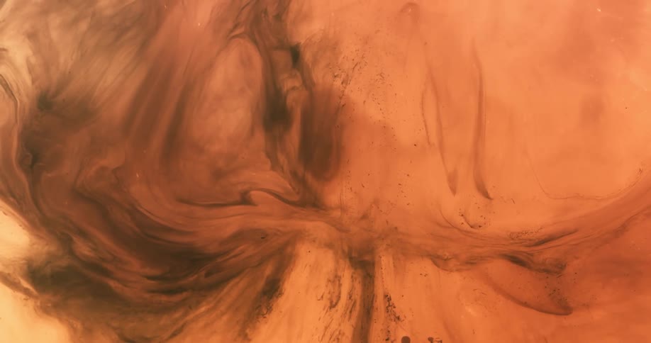 A swirling liquid in different shades of brown and orange