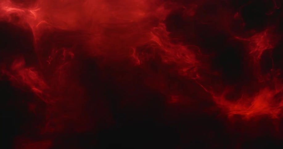 Glowing red smoke fills a black room
