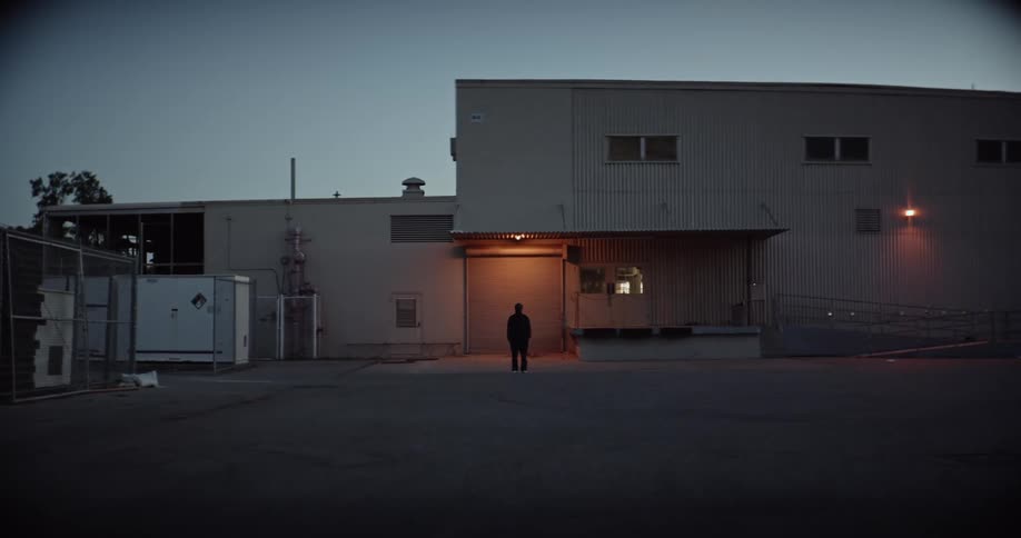 Person stands silhouetted outside business facility in center of fisheye view