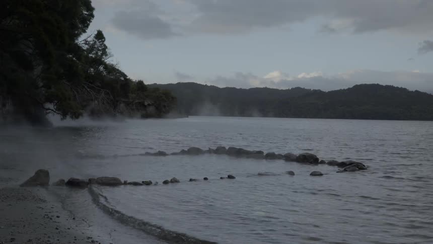 Ocean water steaming up on the beach on a cloudy day