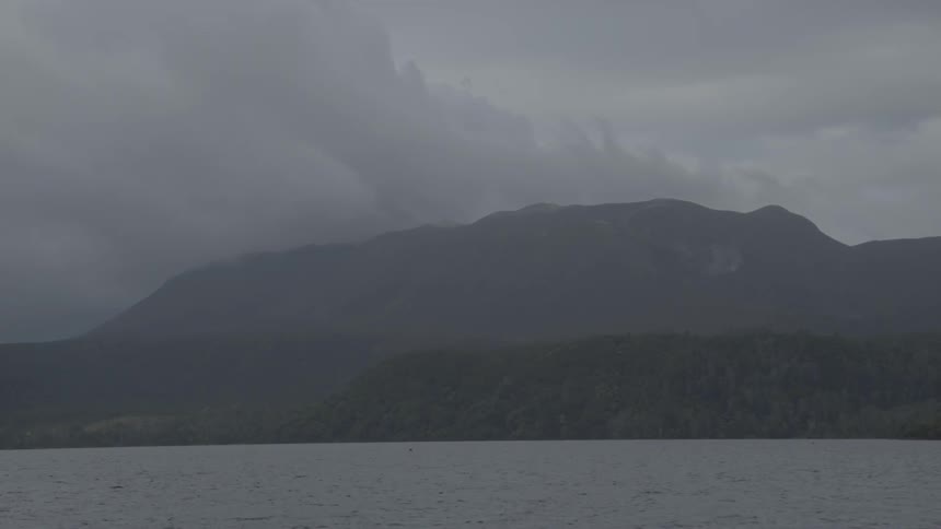 Clouds and fog billow of the top of a mountain