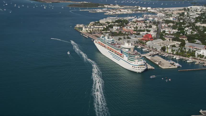 An aerial shot of a Royal Caribbean cruise ship approaching a dock in Key West Florida for a day of sightseeing and recreation