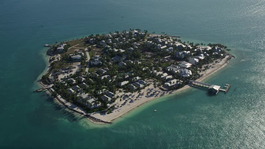 Approaching residential neighborhoods and beachfront properties on Sunset Key in Key West Florida captured through stunning 5K aerial footage