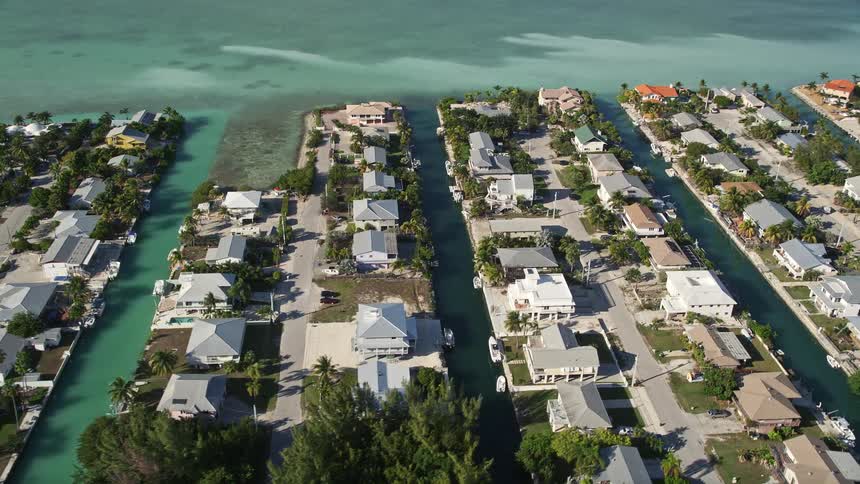 Aerial footage of a coastal community in Big Coppitt Key Florida featuring rows of houses separated by small waterways and piers